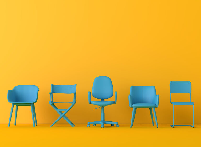 image of a row of blue chairs against a yellow wall